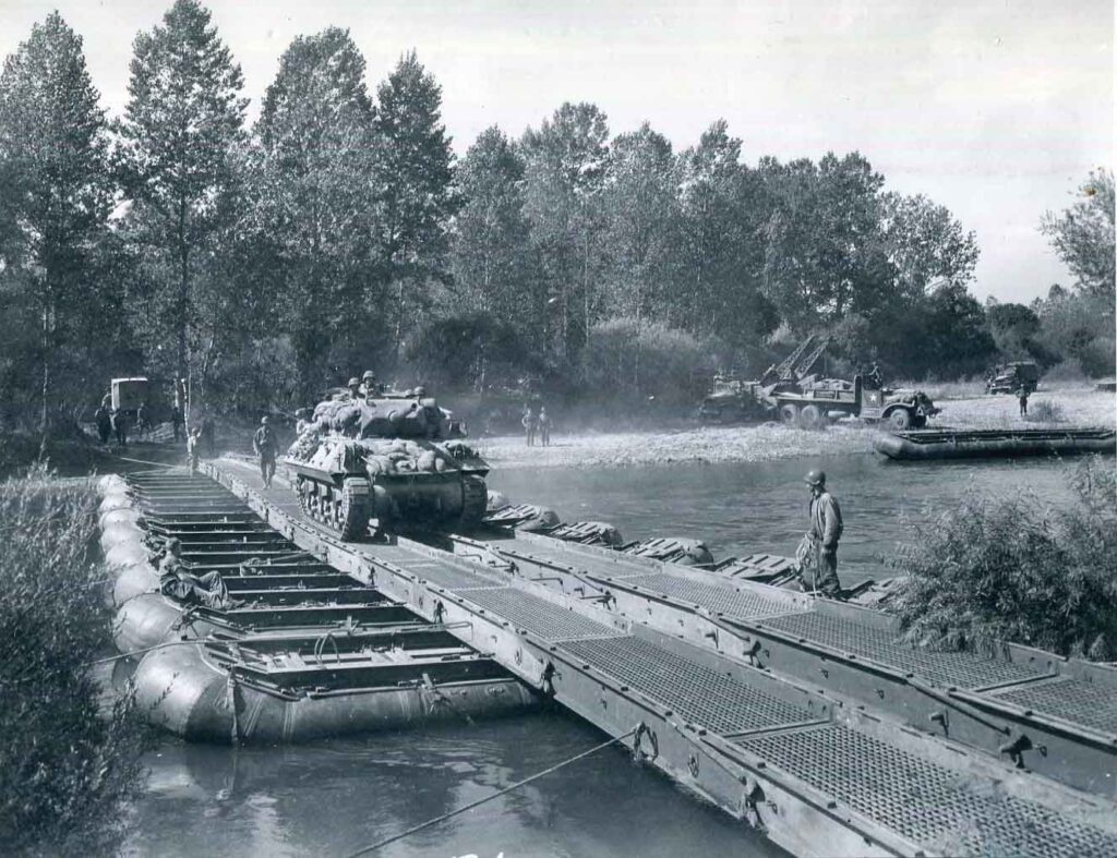 An M10 tank destroyer of the 4th Armored Division crosses the Moselle River near Nancy, France, on a bridge built by Army engineers, 12 September 1944. Three days later, Clarke’s Combat Command A (CCA) liberated Nancy. (National Archives)