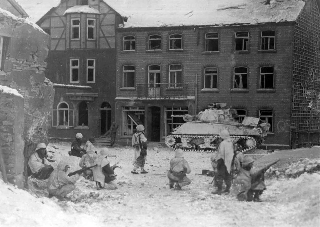 Soldiers of the 23d Armored Infantry Battalion in Clarke’s CCB,  7th Armored Division, watch for snipers and holdouts in St. Vith, Belgium, 23 January 1945. (National Archives)