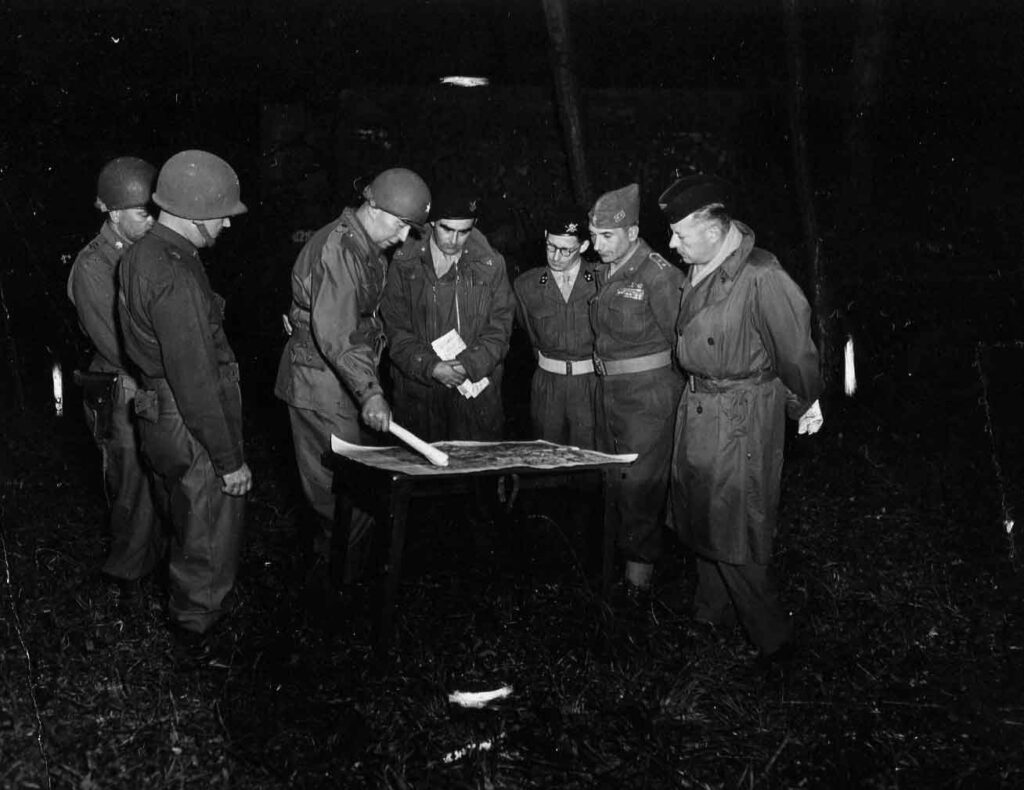 Brigadier General Clarke holds a briefing with Belgian, Italian, and French Army officers during training maneuvers with the 2d Constabulary Brigade in Germany, 12 September 1950. (National Archives)