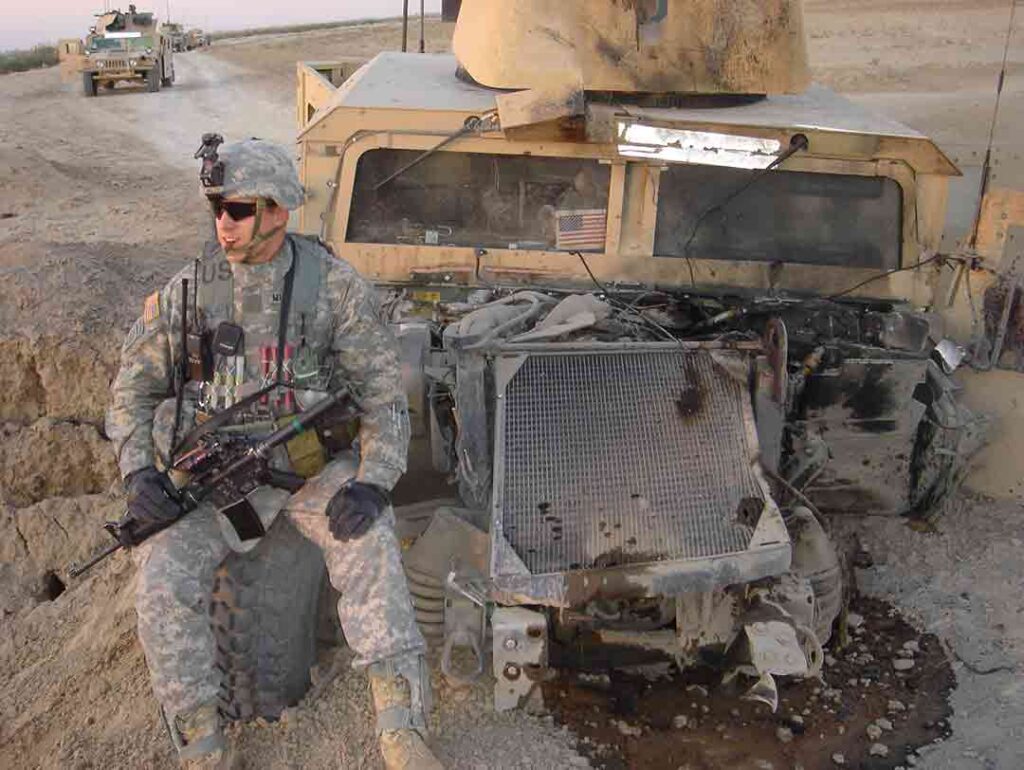 Captain Stephen Dobbins, commanding officer of Bravo Troop, sits on the front of his Humvee that was destroyed by an insurgent landmine on 15 November. Despite his wounds, Dobbins refused evacuation, helped extricate soldiers from the wrecked vehicle, and led his troopers in repelling a coordinated enemy ambush. Dobbins was later awarded the Silver Star for his actions. (Michael Clemens) 