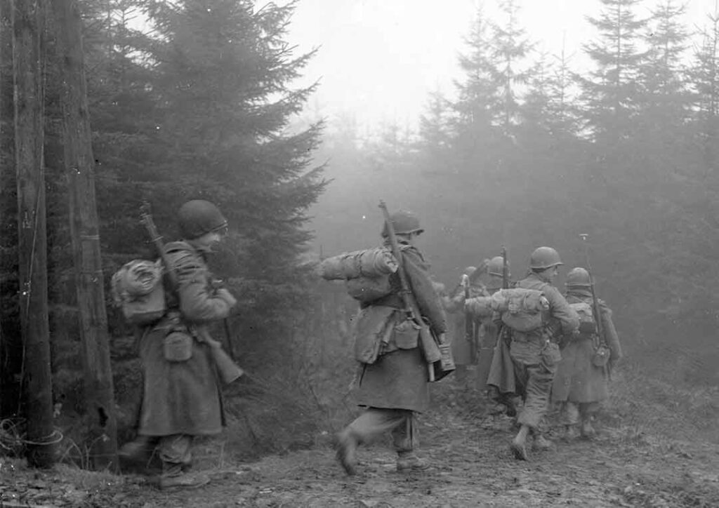 Soldiers from 2d Battalion, 325th Glider Infantry Regiment (GIR), march through heavy fog near Werbormont, Belgium, 20 December 1944. (National Archives) 