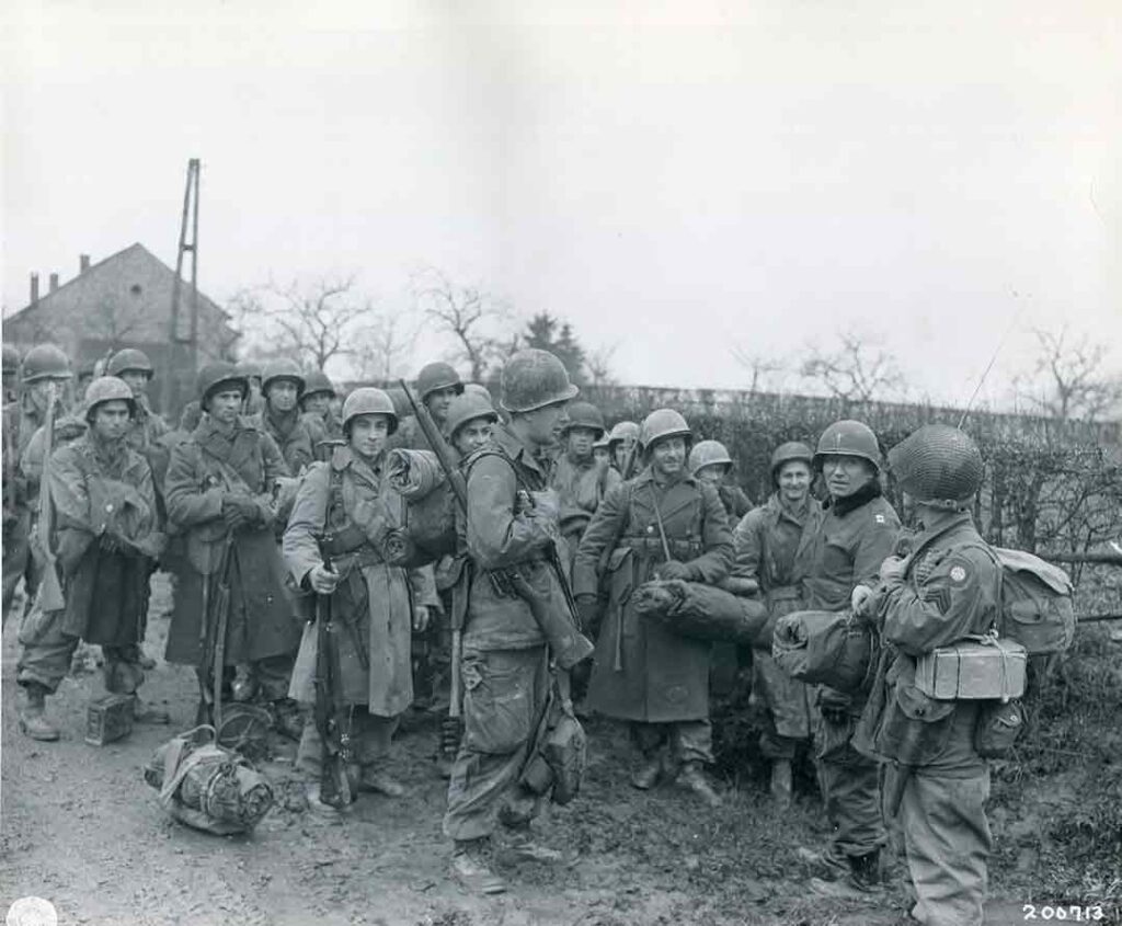 A Catholic chaplain holds a brief service for soldiers of Company D, 2d Battalion, 504th PIR, as they move up to relieve 1st Battalion at Cheneux, 22 December 1944. (National Archives) 